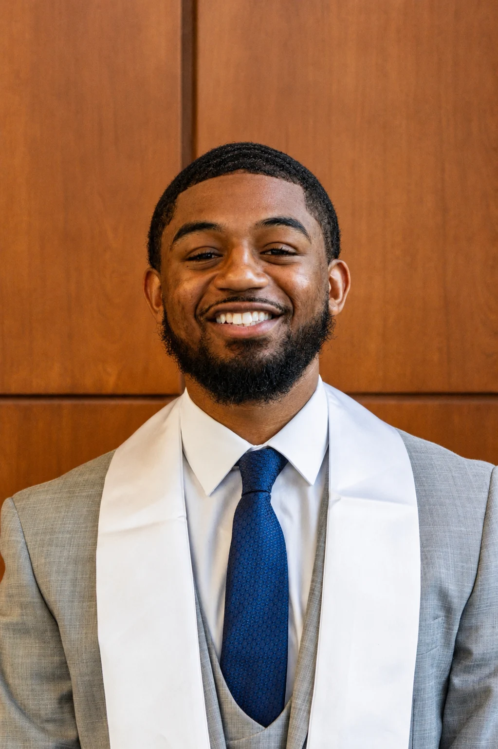 Craig Berry II smiling in a gray suit and blue tie